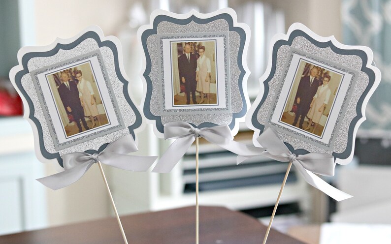 May include: Three silver glitter picture frames with white borders and a silver ribbon bow. Each frame holds a black and white photo of a couple.