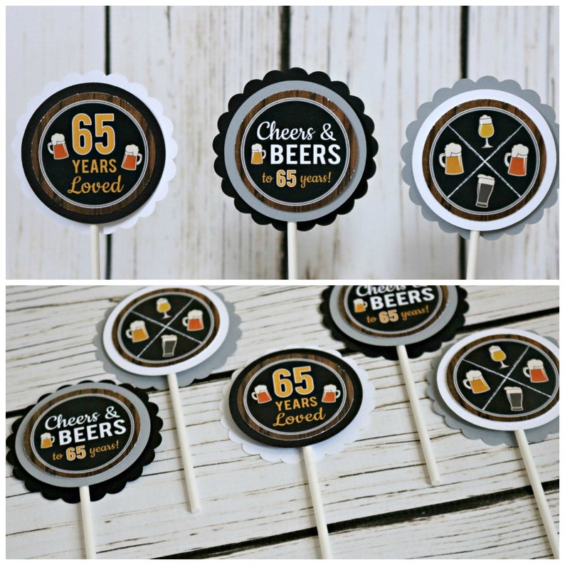 May include: Set of six cupcake toppers with a wood grain background. The toppers feature a black and white design with a beer mug and the text "Cheers & Beers to 65 years!" and "65 Years Loved".