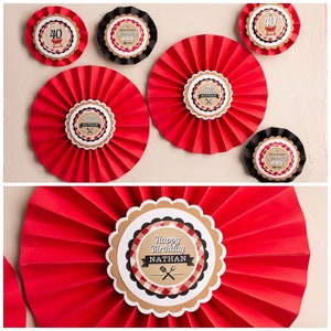 May include: Red and white paper fan decorations with a brown circle in the center. The circle has a black and white checkered pattern and the text "Happy Birthday Nathan".