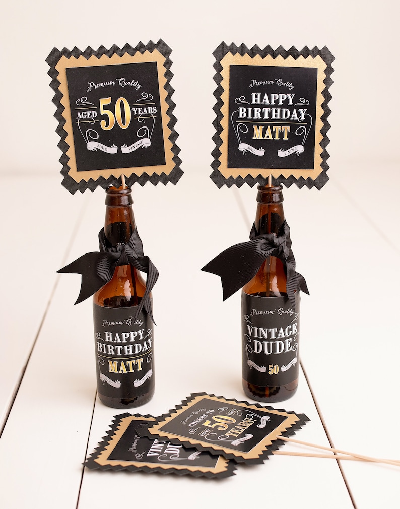 May include: Two black and gold bottle toppers with the text "Aged 50 Years" and "Happy Birthday Matt". Two black and gold bottle labels with the text "Happy Birthday Matt" and "Vintage Dude 50".