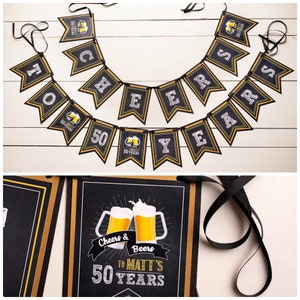 Op de afbeelding: Een zwart en goudkleurig spandoek met de tekst "Cheers & Beers to Matt's 50 Years". De banner heeft een biermok-afbeelding en is geregen met zwart lint. Een feestelijke decoratie voor een 50e verjaardag.