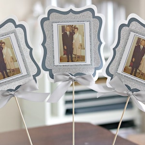 May include: Three silver glitter picture frames with white borders and a silver ribbon bow. Each frame holds a black and white photo of a couple.