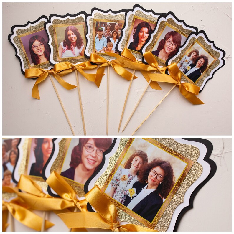May include: A set of six gold glitter picture frames with black borders and white scalloped edges. Each frame features a different vintage photograph of people. The frames are attached to wooden sticks.