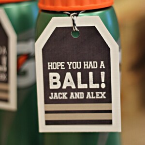 K&ouml;nnte beinhalten: Gr&uuml;ne Wasserflasche mit orangefarbenem Deckel und einem schwarz-wei&szlig;en Etikett mit der Aufschrift "Hoffe, du hattest Spa&szlig;! Jack und Alex".