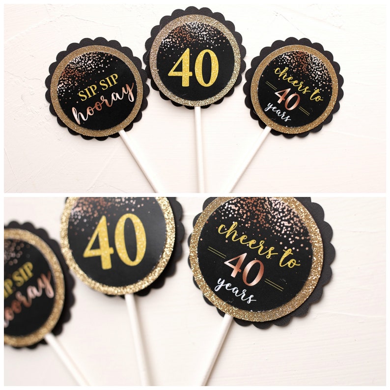 May include: Six black and gold cupcake toppers with a glitter finish. The toppers feature the text "Sip Sip Hooray", "Cheers to 40 Years", and the number "40".