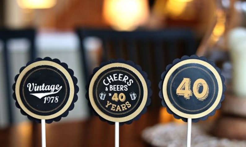 May include: Three black and gold round cupcake toppers with scalloped edges. The toppers feature the text "Vintage 1978", "Cheers & Beers to 40 Years", and "40".