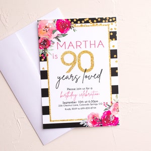 May include: A birthday invitation with a floral design and the text "MARTHA is 90 years loved." The invitation has a gold glitter border and black and white stripes. A white envelope is next to the invitation.