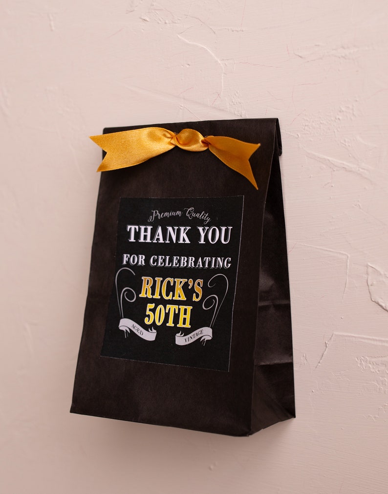May include: Black paper gift bag with a gold ribbon and a thank you tag that says "Premium Quality Thank You for Celebrating Rick's 50th Aged Vintage".
