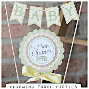May include: A green and yellow baby shower centerpiece with a banner that reads "BABY" and a round topper that says "A New Chapter" with a stack of books.