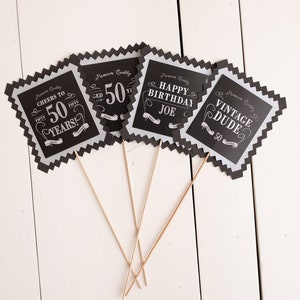Puede incluir: Cuatro accesorios de cabina de fotos en blanco y negro con un tema de cumplea&ntilde;os n&uacute;mero 50. Los accesorios presentan el texto "Cheers to 50 Years!" "50", "Happy Birthday Joe" y "Vintage Dude".