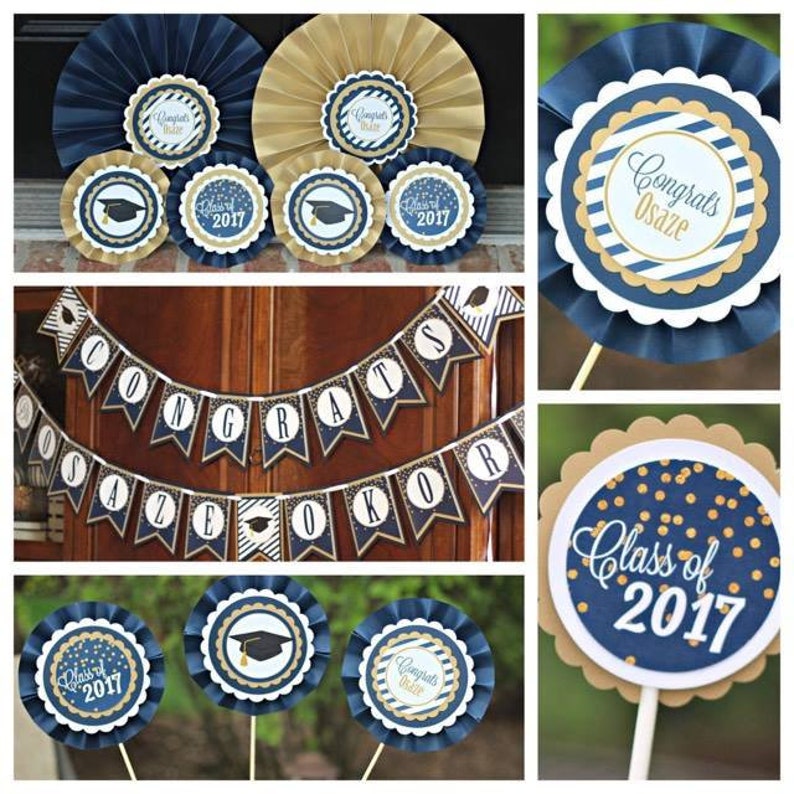 May include: Graduation party decorations in navy blue and gold. The decorations include a banner that says "Congrats Osaz&eacute; Okor", paper fans with gold and navy blue stripes, and a paper fan with gold confetti and the text "Class of 2017".