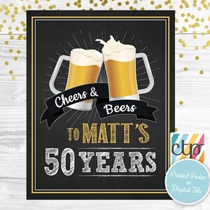 Op de afbeelding: Zwart schoolbord-stijl poster met twee bierpullen die klinken. De tekst luidt "Cheers & Beers" boven "To Matt's 50 Years". Gouden accenten en een banner dragen bij aan het ontwerp. Een klein logo geeft aan dat het een gedrukte poster of digitaal bestand is.