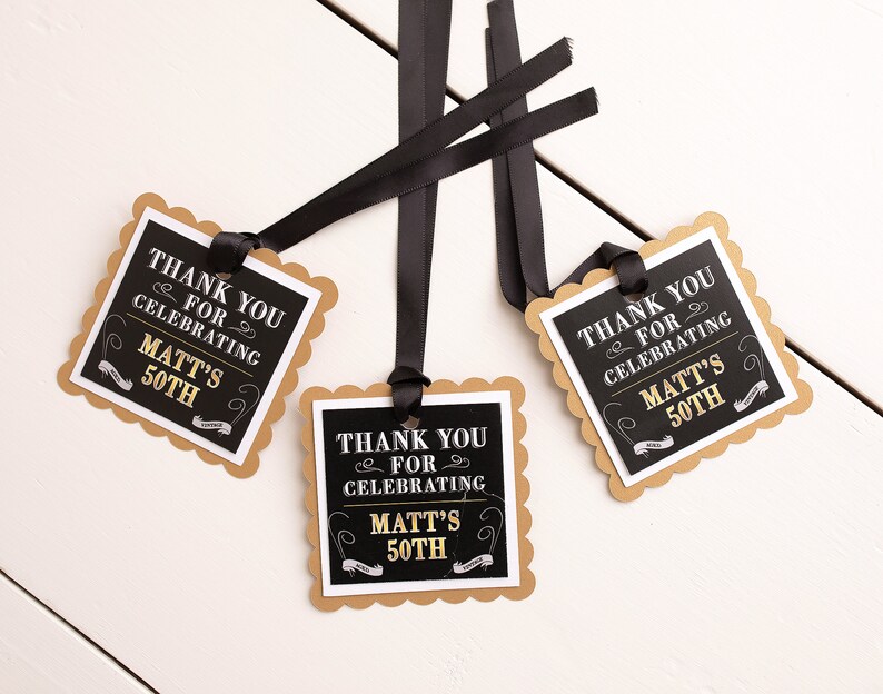 May include: Three black and gold favor tags with scalloped edges. The tags are tied with black ribbon and feature the text "Thank you for celebrating Matt's 50th".