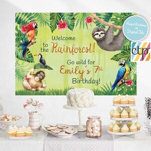 May include: A green, yellow, and blue rainforest-themed birthday party backdrop with a sloth, toucans, and parrots. The text reads "Welcome to the Rainforest! Go wild for Emily's 7th Birthday!"