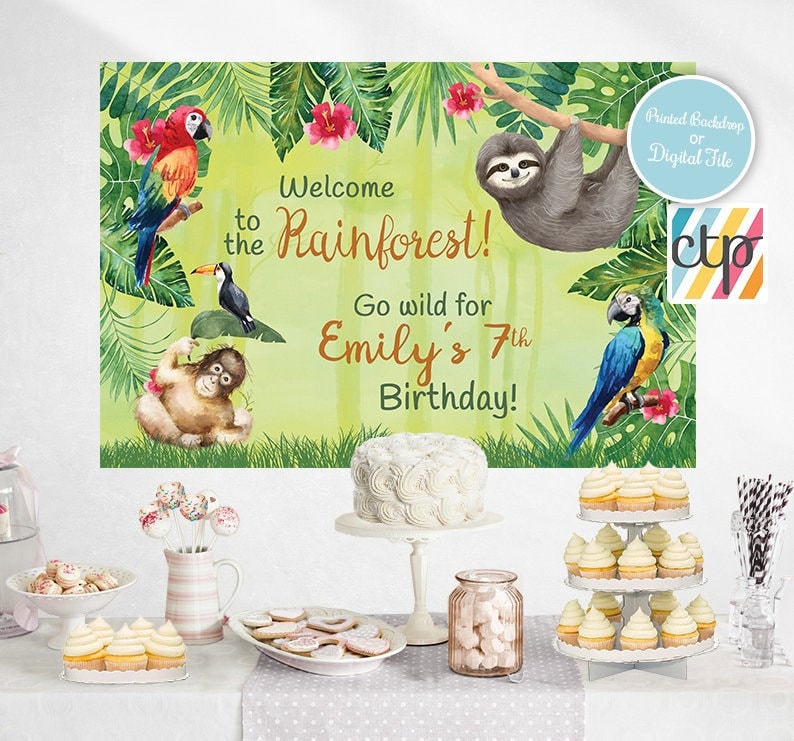 May include: A green, yellow, and blue rainforest-themed birthday party backdrop with a sloth, toucans, and parrots. The text reads "Welcome to the Rainforest! Go wild for Emily's 7th Birthday!"
