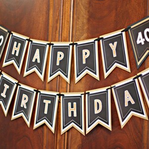 May include: Black and gold banner with the text "40 Happy Birthday" in gold letters on black flags.
