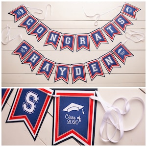 May include: A graduation banner with red, white, and blue colors. The banner says "Congrats Hayden" and has a graduation cap icon on each end. There is also a separate banner that says "Class of 2020" with a graduation cap icon.