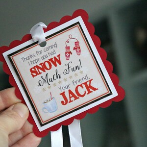 May include: A square gift tag with a red scalloped border and white ribbon. The center features the text 'Thanks for coming! I hope you had SNOW Much Fun! Your friend, JACK' alongside illustrations of red mittens and a blue mug with a striped straw.
