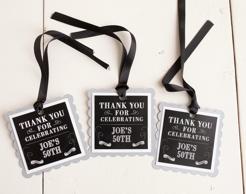 May include: Three black and white thank you tags with scalloped edges and black ribbon. The tags say "Thank you for celebrating Joe's 50th".