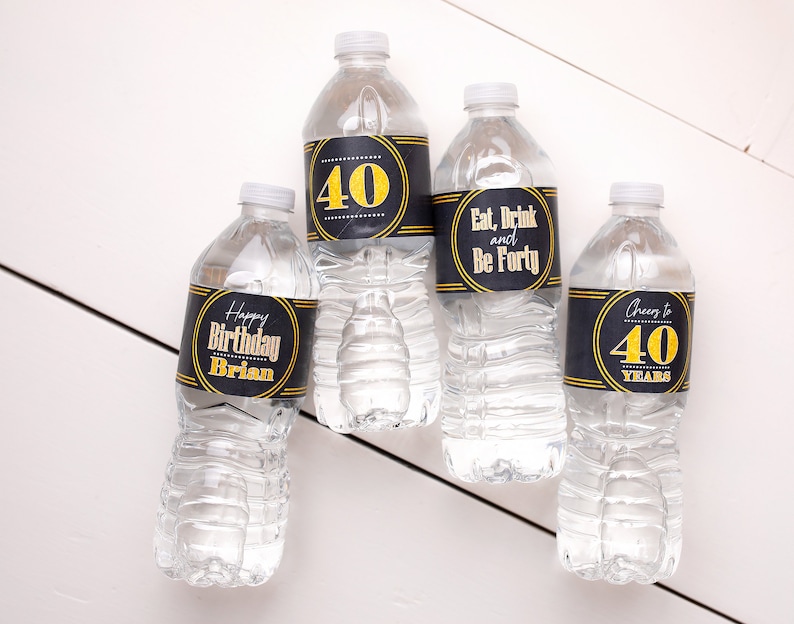 May include: Four clear plastic water bottles with black and gold labels. The labels have different text, including "Happy Birthday Brian", "40", "Eat, Drink and Be Forty", and "Cheers to 40 Years".