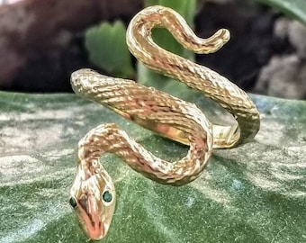 k14 gold snake ring with green gemstone eyes.