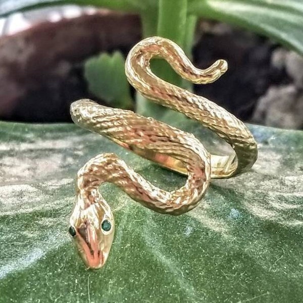 k14 gold snake ring with green gemstone eyes.