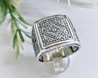 Silver mens signet ring with religious engravings.