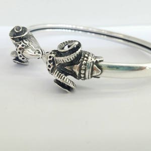 A ram head bracelet in solid silver 925.
The silver ram bracelet consists of two silver ram heads on a silver torc tube.
The ram bracelet is handmade and has a beautiful oxidation giving a contrast to the ram horns and ram head details.