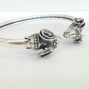 A ram head bracelet in solid silver 925.
The silver ram bracelet consists of two silver ram heads on a silver torc tube.
The ram bracelet is handmade and has a beautiful oxidation giving a contrast to the ram horns and ram head details.