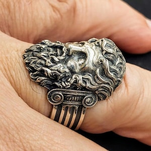 Silver Zeus ring on man's finger showing the Ionic columns on the shank