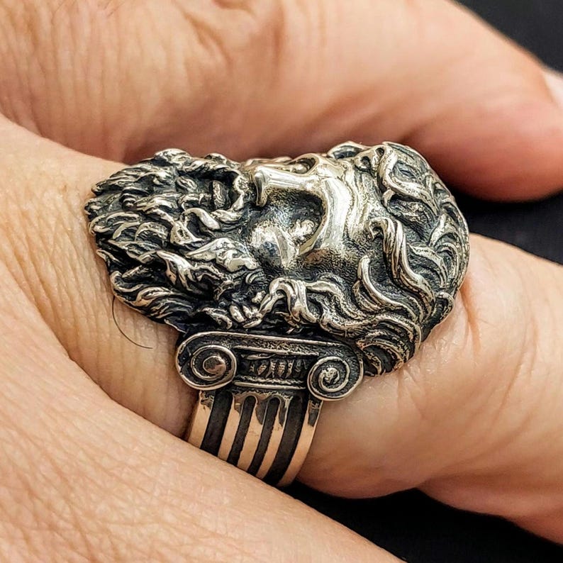 Silver Zeus ring on man's finger showing the Ionic columns on the shank