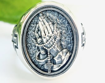 Sterling silver signet ring with praying hands and a rosary, religious statement jewellery