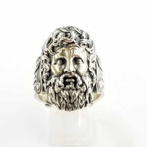 A large silver ring featuring the powerful figure of Zeus, the king of the gods, intricately carved atop a sturdy band.  Flanked by majestic Greek columns on each side, this bold statement piece exudes strength, sophistication, and timeless appeal.
