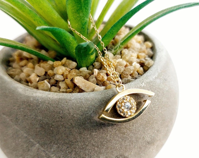 14K gold eye necklace with zirconia gemstones and stackable gold chain.