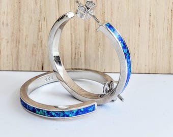 Sterling silver hoop earrings with blue opal inlay.