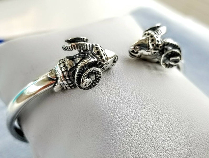 A ram head bracelet in solid silver 925.
The silver ram bracelet consists of two silver ram heads on a silver torc tube.
The ram bracelet is handmade and has a beautiful oxidation giving a contrast to the ram horns and ram head details.