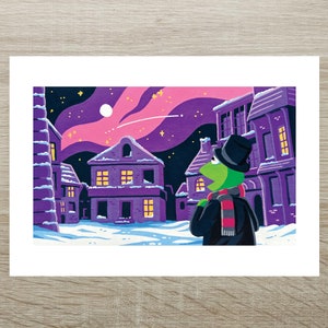 May include: A colourful print depicting a green frog character in a top hat and scarf, looking up at a starry night sky above a snow-covered town. The buildings are purple with lit windows, and the sky is a gradient of pink and purple.