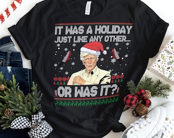 May include: Black t-shirt with a Christmas-themed design featuring a man in a Santa hat and the text "It was a holiday just like any other... or was it?"