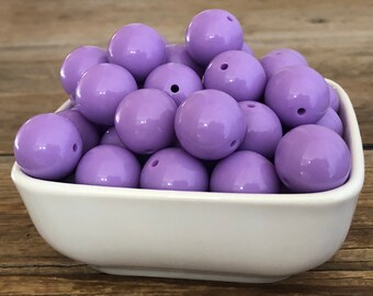 May include: A bowl filled with purple silicone beads. The beads are round and have a glossy finish.