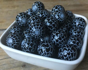 May include: A bowl filled with black and white spiderweb patterned marbles.