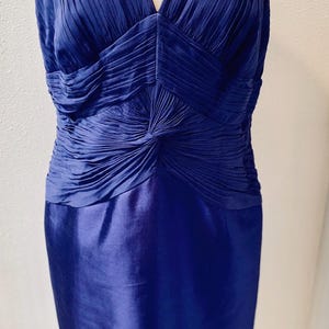 May include: A sleeveless royal blue dress with a pleated bodice and a fitted skirt.