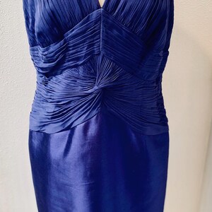 May include: A sleeveless royal blue dress with a pleated bodice and a fitted skirt.