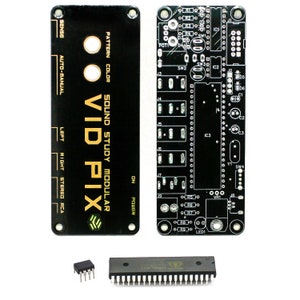 Op de afbeelding: Een zwarte printplaat met gouden tekst die "SOUND STUDY MODULAR VID PIX" luidt. De printplaat heeft verschillende componenten, waaronder een potentiometer, schakelaars en een chip.