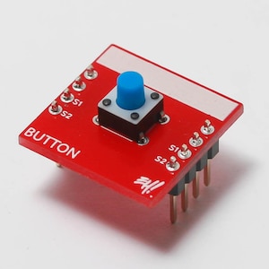 May include: A red circuit board with a blue button and the text "BUTTON" printed on it. The board has six gold-colored pins on the side.