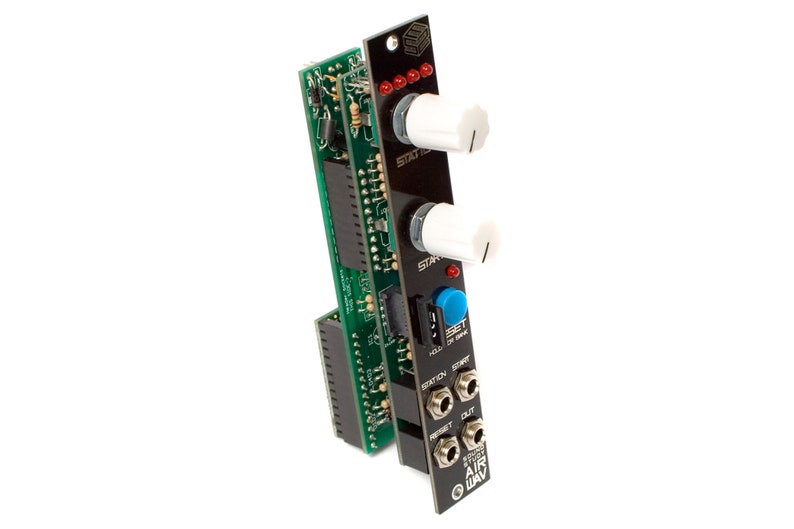 May include: A black and green electronic music module with white knobs and a blue button. The module has the text "RETURN TO AIRWAY" printed on it.
