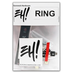 Könnte beinhalten: Eine transparente Plastiktüte mit einem schwarzen Eurorack Hardware RING-Modul, einer kleinen Schraubentüte und einem Aufkleber mit dem Eurorack Hardware-Logo. Das Modul hat eine rote LED und einen schwarzen Knopf. Der Aufkleber zeigt "Eurorack Hardware" und "EHI!" in einer stilisierten Schrift.