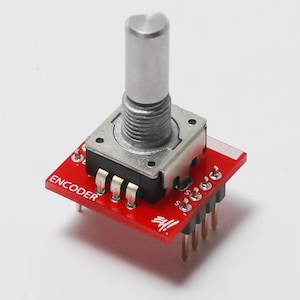 May include: A red rotary encoder with a silver knob and the word "ENCODER" printed on the board.