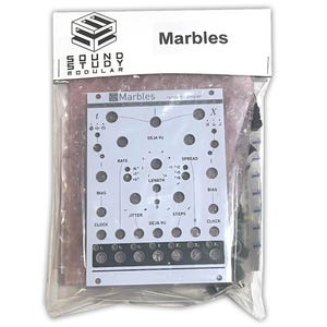 Puede incluir: Un módulo electrónico blanco "Marbles" con varias perillas y entradas, empaquetado en una bolsa de plástico transparente. El módulo tiene el logotipo y el texto "Sound Study Modular", con etiquetas adicionales como "Rate", "Bias" y "Clock".