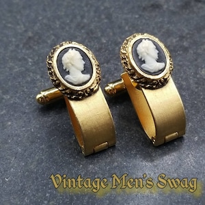 Op de afbeelding: Een paar gouden manchetknopen met zwart-witte cameoportretten. De cameo's zijn ingelijst in gouden frames met een decoratieve rand.