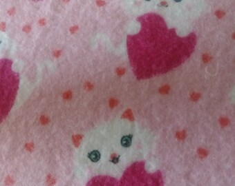 Peut inclure: Tissu rose avec un motif répété de chats blancs tenant des cœurs roses. Le fond est recouvert de petits cœurs roses.